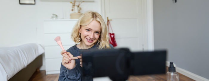 Portrait of smiling young woman using mobile phone