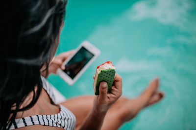 Midsection of woman holding mobile phone