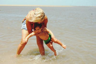 Full length of woman with child at beach