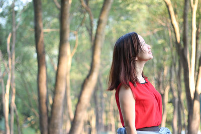 Young woman standing in forest