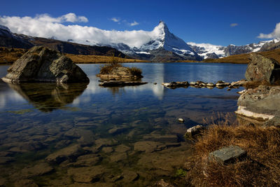 Scenic view of lake and snowcapped mountains against sky