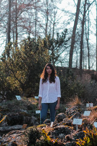 Portrait of young woman standing in forest