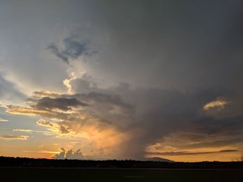 Scenic view of silhouette field against sky during sunset