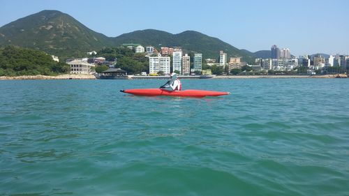 Boats in sea with buildings in background