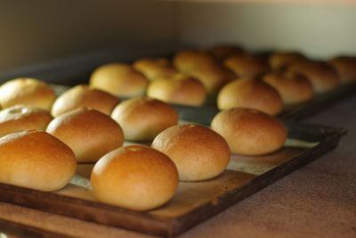 Close-up of fresh bun breads on board in bakery