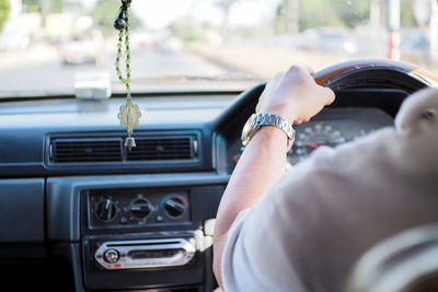 Cropped image of man driving car