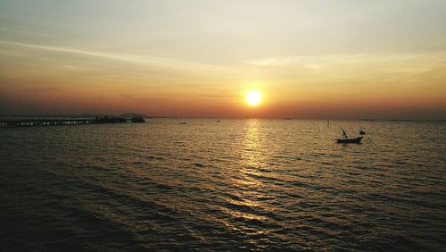 Scenic view of sea against dramatic sky during sunset