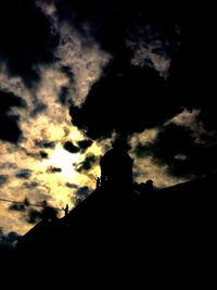 Silhouette of building against cloudy sky