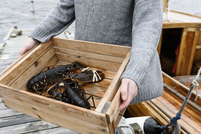 Woman carrying lobsters, close-up