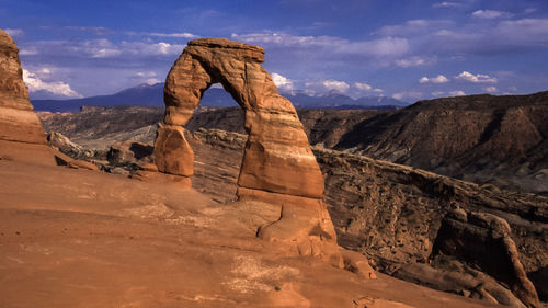 Rock formations on landscape against cloudy sky