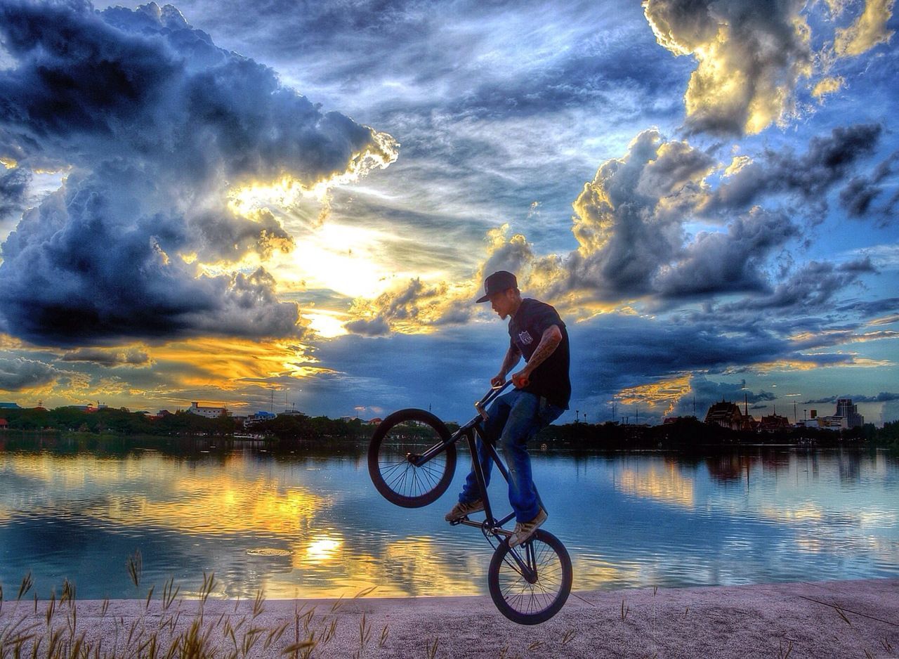 bicycle, sky, transportation, mode of transport, water, lifestyles, cloud - sky, leisure activity, men, full length, riding, land vehicle, cloud, cloudy, sunset, side view, cycling, travel