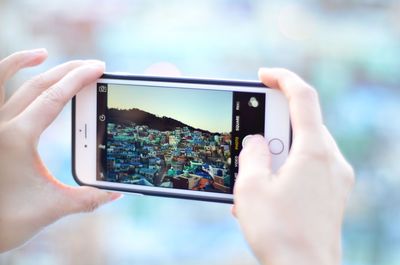 Midsection of woman photographing with mobile phone