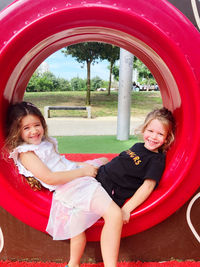 Portrait of smiling young woman sitting in park