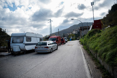 Cars on street in city against sky