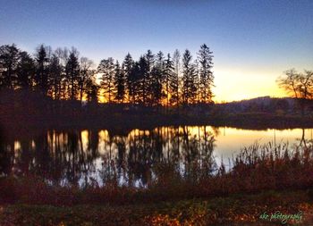 Scenic view of lake against sky at sunset