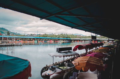 People on boat in river against sky