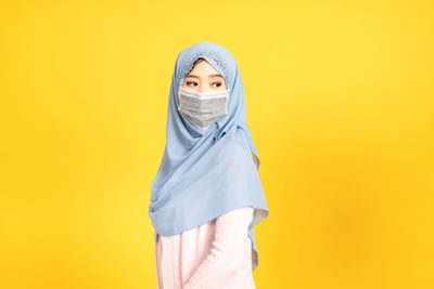 Portrait of a woman against yellow background