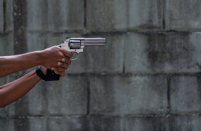 Midsection of man holding metal against wall