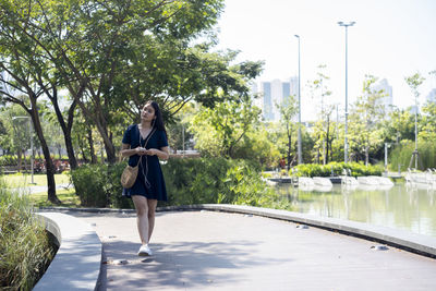 Full length of woman walking on footpath at park