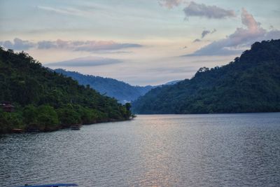 Scenic view of river by mountains against sky