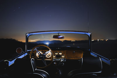 Illuminated vintage car against sky at night