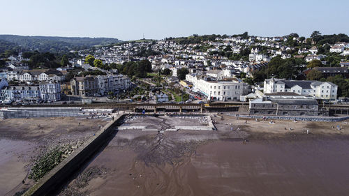 High angle view of buildings by river against sky