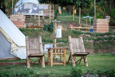 Empty chairs and table on field