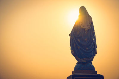 Statue against clear sky during sunset