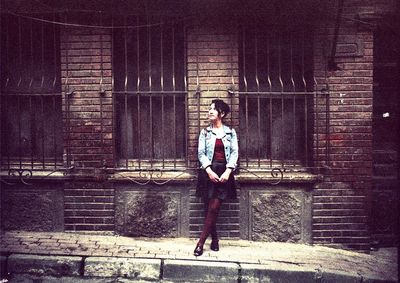 Full length of young man standing on wall