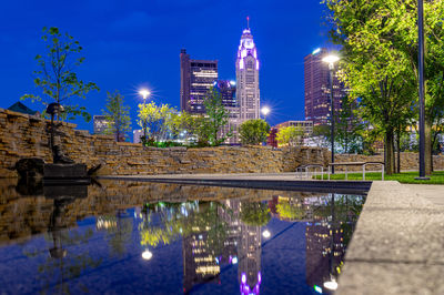 Reflection of illuminated buildings in pond at night