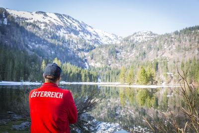 Man standing by lake against mountain