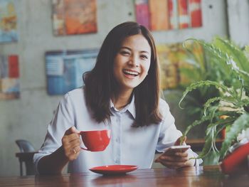 Portrait of a smiling young woman sitting at restaurant