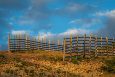 Fence on field against sky