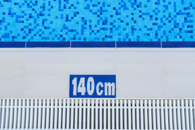 Text on wall by swimming pool