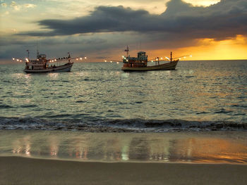 Ship sailing in sea against sky during sunset
