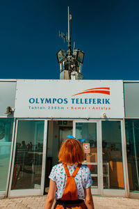 Rear view of woman standing against clear sky