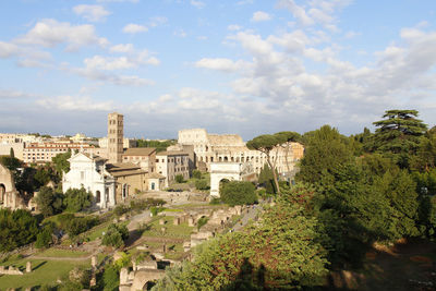 Aerial panoramic cityscape view of the roman forum and roman colosseum during sunset in rome, italy