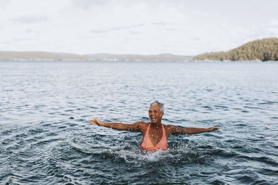 Portrait of shirtless man swimming in sea