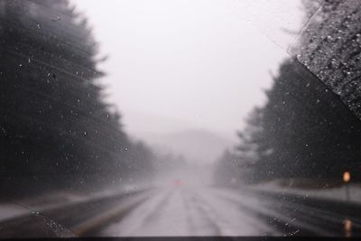 Road seen through wet windshield during rainy season