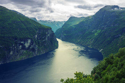 Scenic view of river amidst mountains against sky