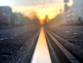 Close-up of railroad tracks against sky during sunset