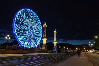 Blurred motion of illuminated ferris wheel at night
