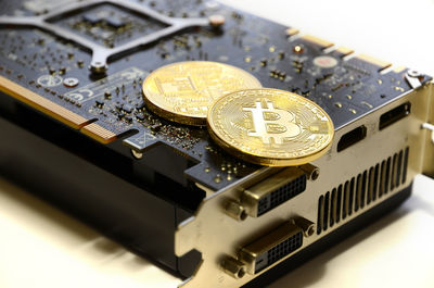 Close-up of bitcoins on computer equipment over white background