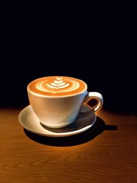 Close-up of cappuccino on table against black background