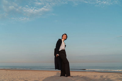 Man standing on beach against sky