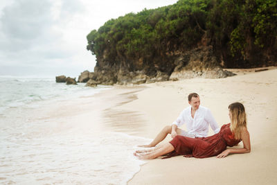 Young couple sitting on beach