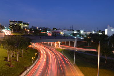 High angle view of light trails on road against clear sky at dusk