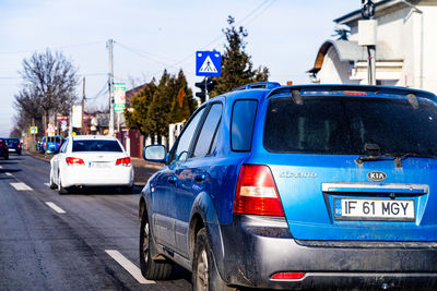 Vehicles on road against blue sky