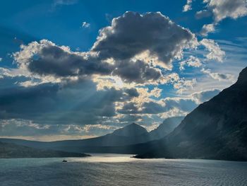 Scenic view of sea and mountains against sky