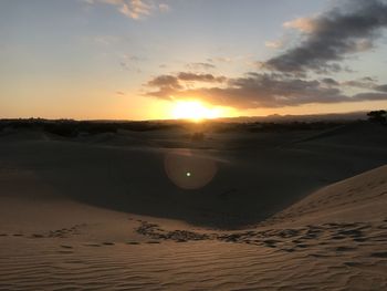 Scenic view of beach against sky during sunset